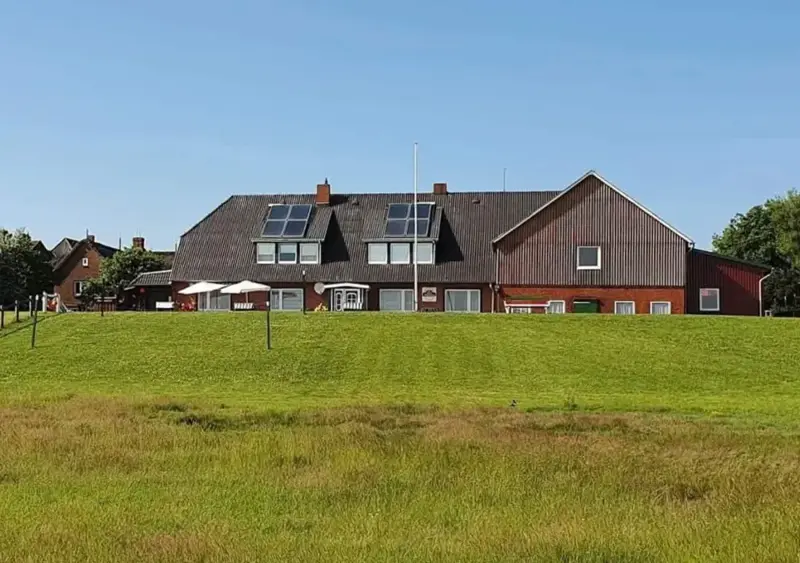 Haus Helgoland auf der Warft, davor die Salzwiese